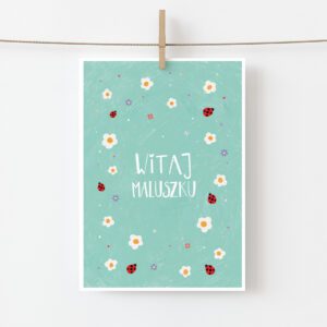 Zdjęcia przedstawia kartkę okolicznościowa z okzaji narodzin dziecka. Na turkusowym tle znajduje się napis: Witaj maluszku oraz rysunki białych i różowych kwiatków oraz biebronek